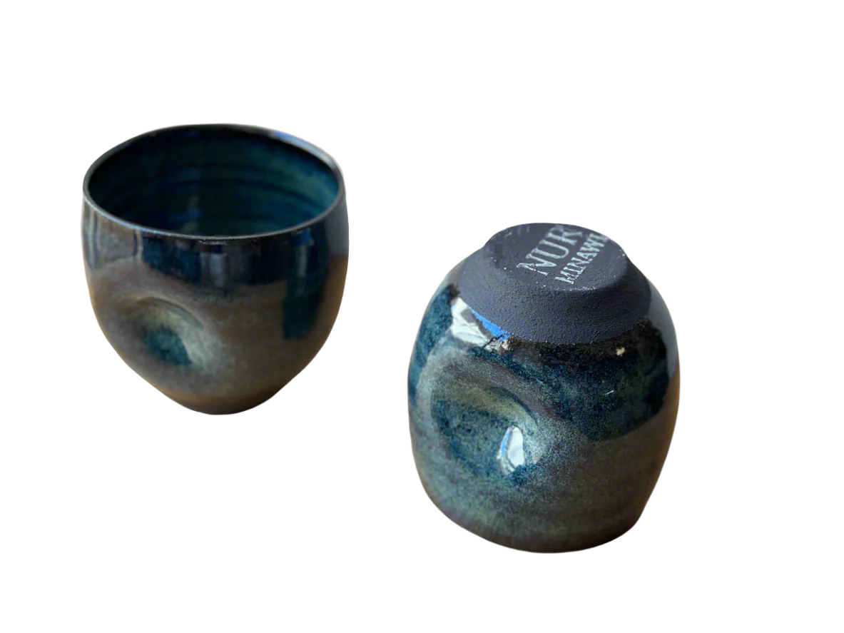 Two ceramic cups with blue and gray glaze on a neutral background