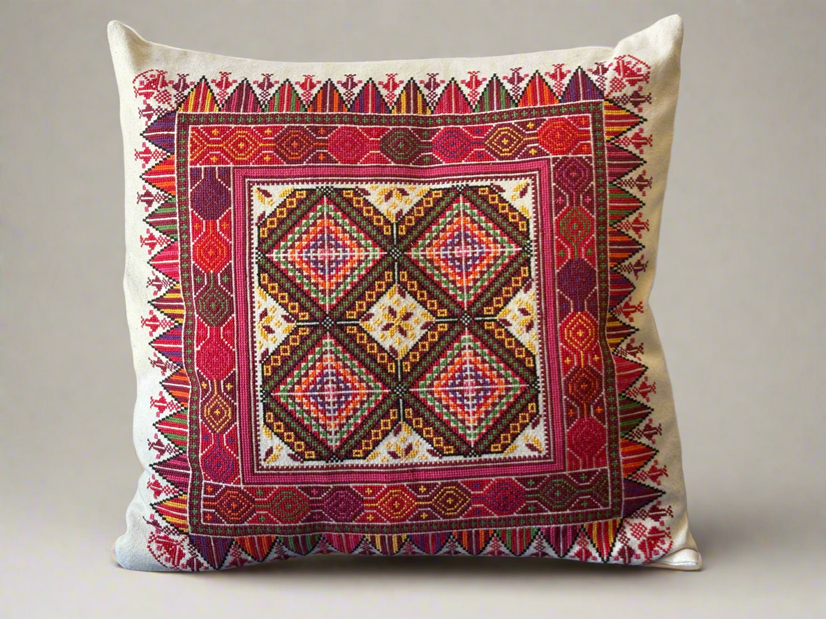 Decorative pillow with intricate geometric hand embroidered Palestinian pattern on a plain background