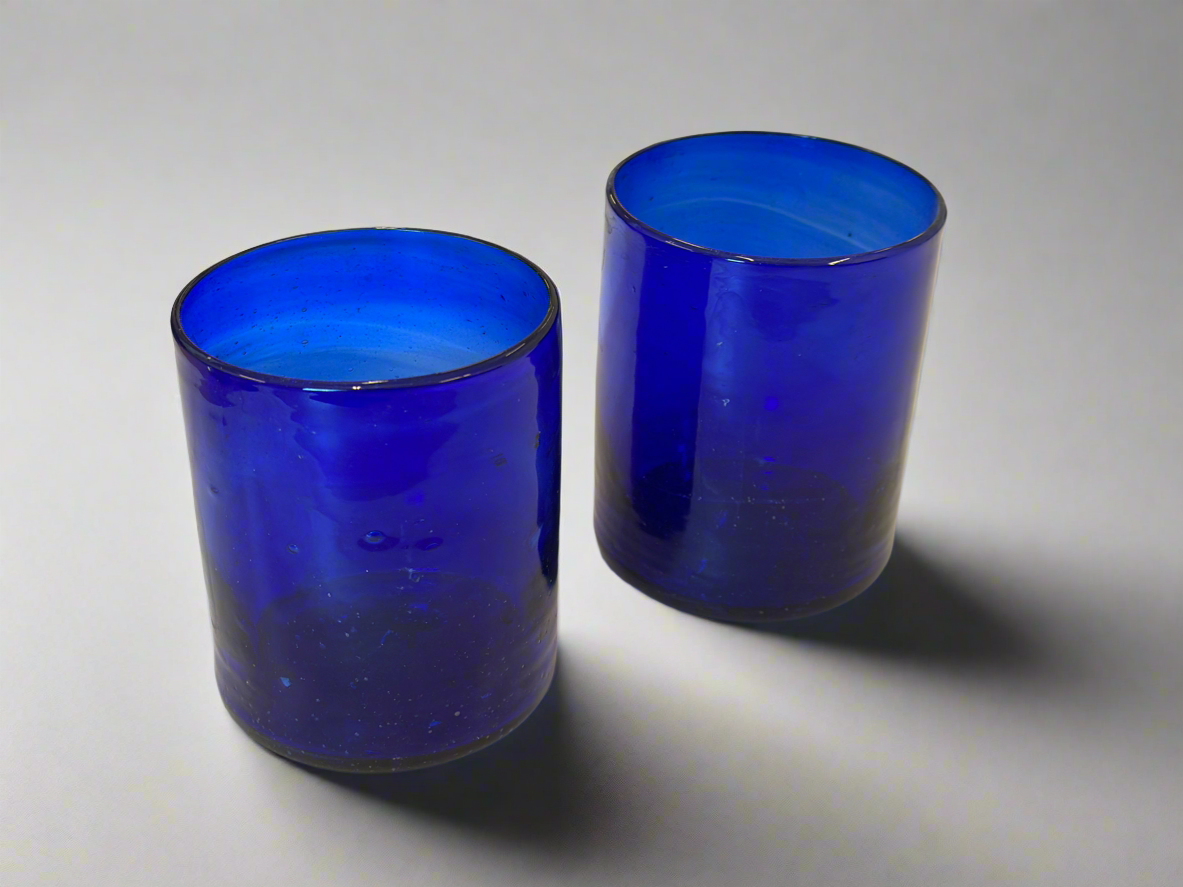 Two blue glass tumblers on a white background