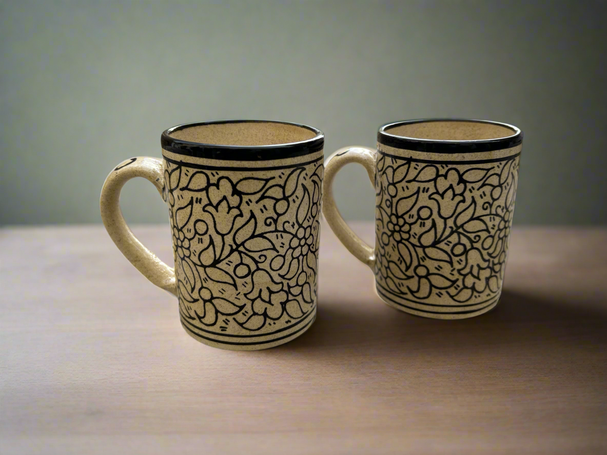 A set of two ceramic mugs with a floral pattern in beige tones, handcrafted and glazed.