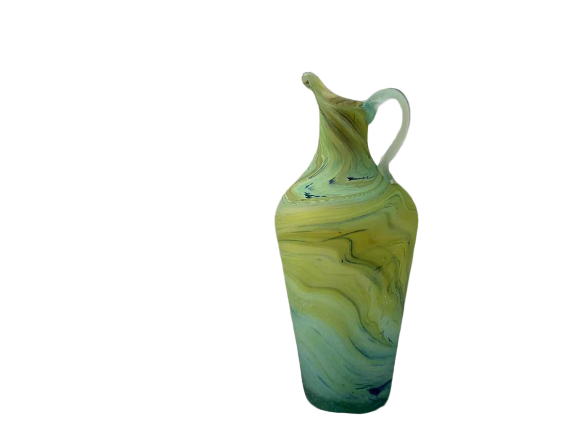A handblown green glass pitcher with swirling patterns, against a neutral background.