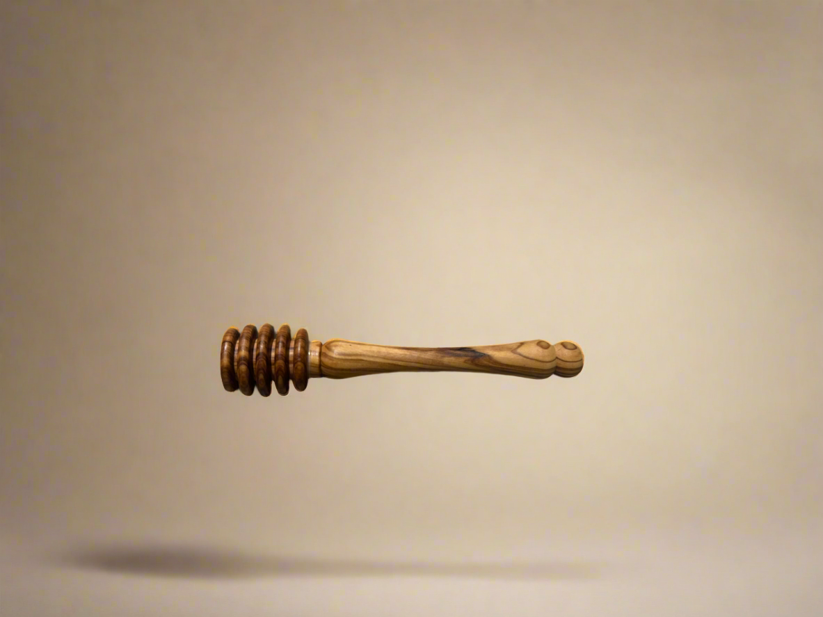 Olive wood honey dipper on a beige background