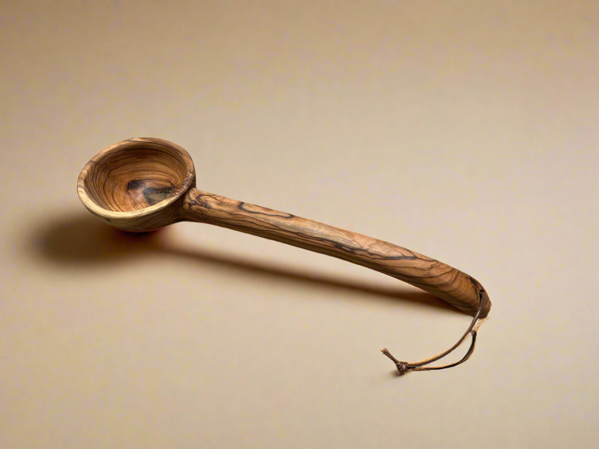 Wooden ladle with a handle on a beige background