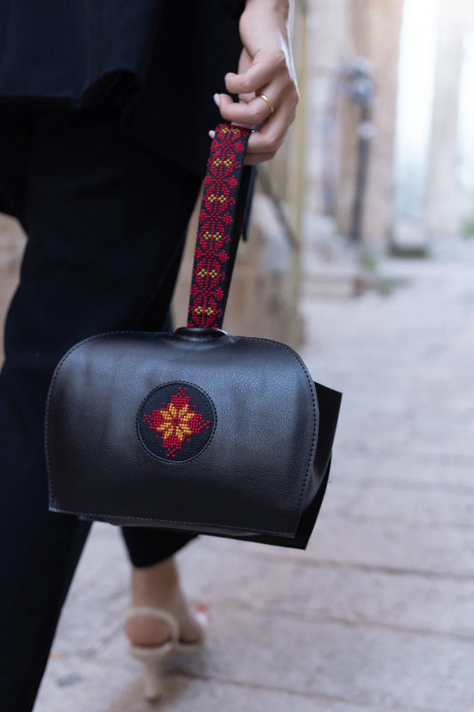 Black pouch with a floral design on a white background