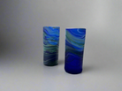 Two handblown Hebron Phoenician glass tumblers with a cobalt blue color, displayed against a neutral background.