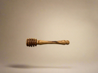 Olive wood honey dipper on a beige background