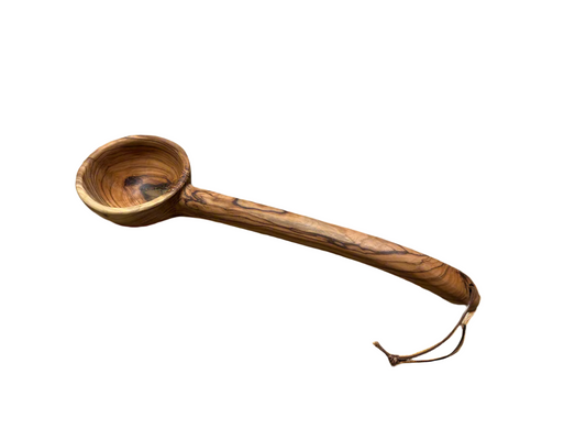 Wooden ladle with a handle on a beige background