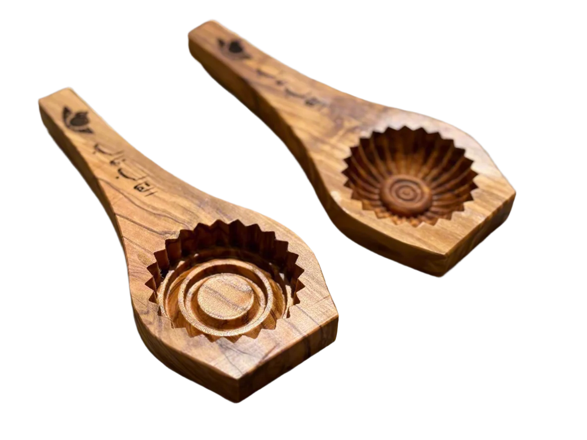 Two olive wood Ma'moul cookie molds with engraved patterns used for making eid cookies.